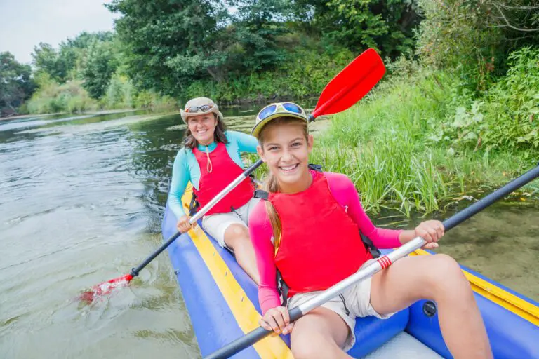 Active happy family. Girl with her mother having fun together enjoying adventurous experience kayaking on the river on a sunny day during summer vacation